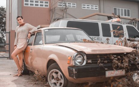 Woman Posing Beside An Abandoned Car